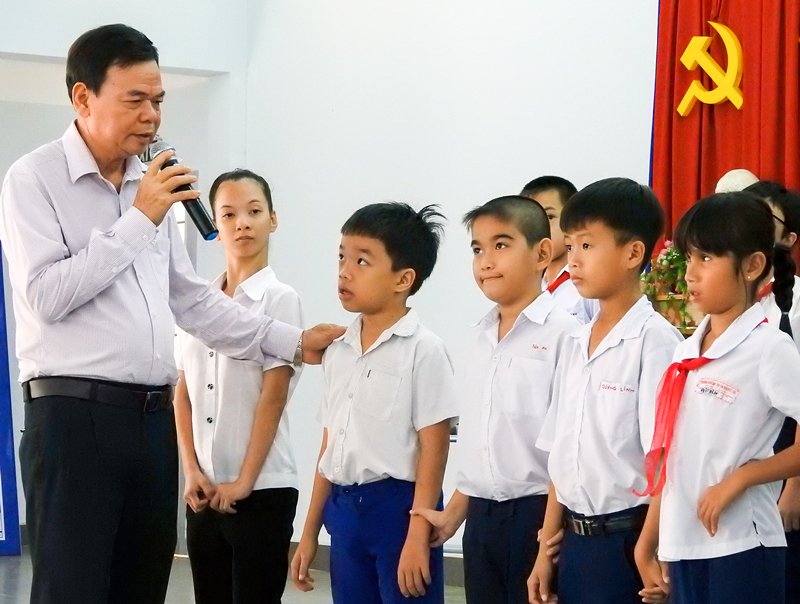 Bí thư Tỉnh ủy Võ Thành Hạo thăm hỏi các em học sinh Trường Nuôi dạy trẻ em khuyết tật tỉnh. Ảnh: T.Đồng