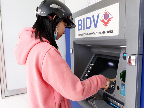 Đảm bảo chất lượng, an toàn ATM dịp Tết Rút tiền tại một điểm ATM. Ảnh:T.Đồng