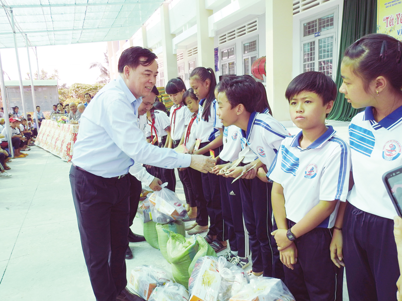 Ấm lòng tình xuân hó bí thư Tỉnh ủy Trần Ngọc Tam trao quà cho các em học sinh trong chương trình “Tết yêu thương” tại huyện Ba Tri. Ảnh: Thanh Đồng