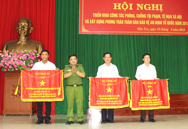 Đại tá Lê Văn Hòa - Phó giám đốc Công an tỉnh trao cờ thi đua của Bộ Công an cho các tập thể xuất sắc. Ảnh: H. Đức