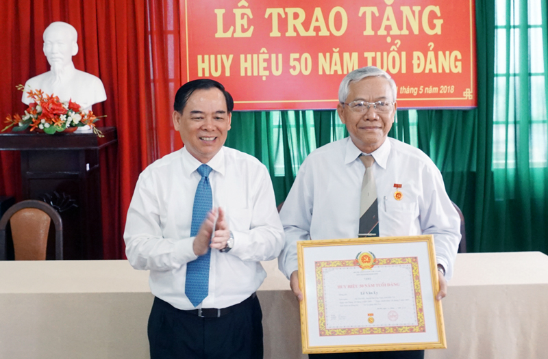 Phó bí thư Tỉnh ủy Trần Ngọc Tam trao tặng Huy hiệu 50 năm tuổi Đảng cho đồng chí Lê Văn Ly. Ảnh: Q.Hùng