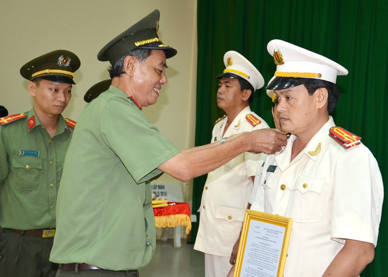 Thiếu tướng Nguyễn Văn Hoàng - Giám đốc Công an tỉnh trao quyết định nâng lương, gắn cấp bậc hàm cho các đồng chi đến niên hạn. Ảnh: Quang Duy