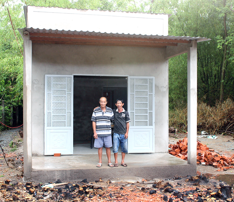 Ông Phạm Hoàng Hải (bên phải) cùng người hàng xóm bên căn nhà mới xây.