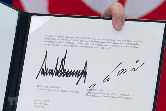 Văn kiện chung lưu lại chữ ký của Tổng thống Mỹ Donald Trump (trái) và của nhà lãnh đạo Triều Tiên Kim Jong-un (phải) tại Sentosa, Singapore ngày 12-6-2018. Nguồn: AFP/TTXVN