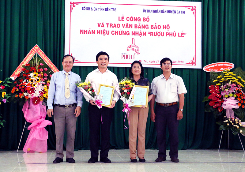 Rượu Phú Lễ được cấp chứng nhận nhãn hiệu Đại diện lãnh đạo UBND huyện Ba Tri trao quyền sử dụng nhãn hiệu “rượu Phú Lễ” cho đại diện Công ty Cổ phần rượu Phú Lễ và Hợp tác xã rượu nếp truyền thống Phú Lễ. Ảnh: Viết Duyên