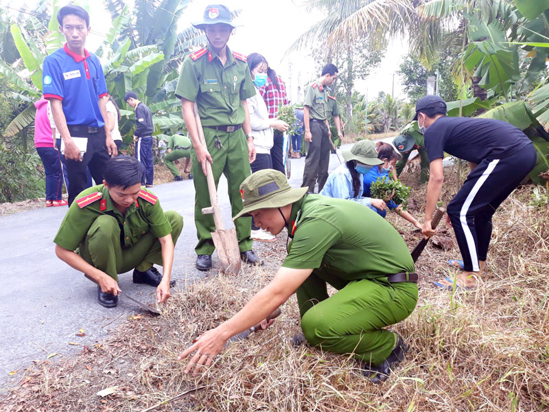 Các chiến sĩ Đoàn Thanh niên Công an tỉnh trồng hoa chỉnh trang các tuyến đường nông thôn xã Phú Túc (Châu Thành).  Ảnh: Thanh Đồng