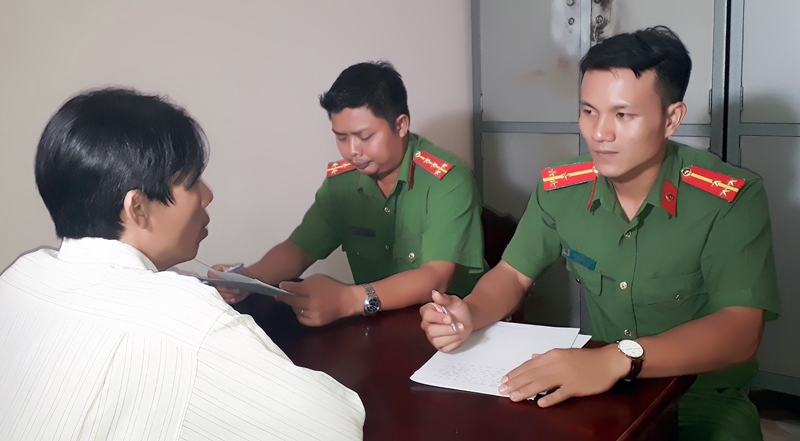 Thượng úy Đoàn Văn Trực (thứ nhất, từ phải sang) cùng đồng đội đang lấy lời khai đối tượng. Ảnh: Minh Tân