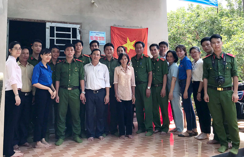 Chi đoàn Trại tạm giam cùng địa phương xã Tân Thạch chụp ảnh lưu niệm với bà Nguyễn Thị Lành tại căn nhà đã được bàn giao.