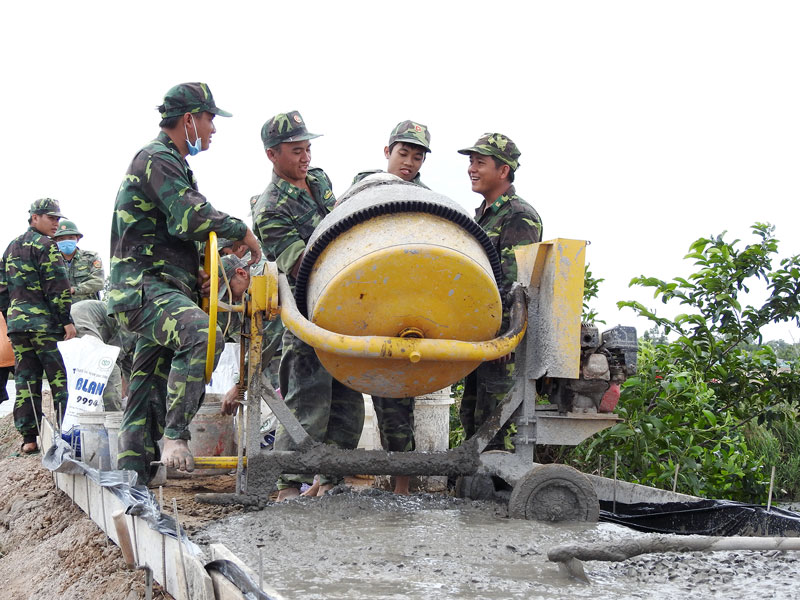 Các chiến sĩ đội Hành quân xanh Bộ Chỉ huy Bộ đội Biên phòng tỉnh bê-tông tuyến đường ấp Giao Tân, xã Giao Thạnh, huyện Thạnh Phú. 