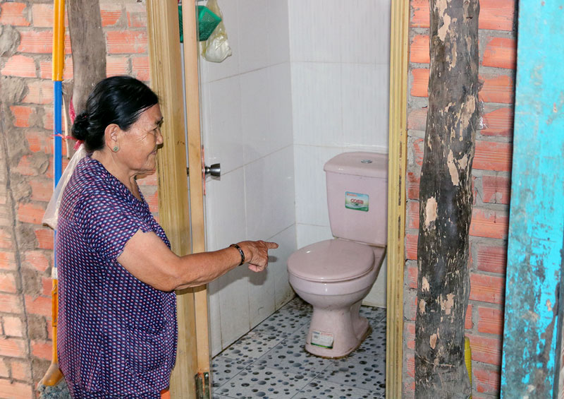 Bà Phạm Thị Rơi - ấp Mỹ Hòa, xã Mỹ Hòa vui vẻ khi xây được hố xí hợp vệ sinh.  Ảnh: P. Hân