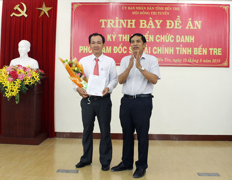 Ông Trần Thanh Tuấn trúng tuyển và đươc bổ nhiệm Phó giám đốc Sở Tài chính Chủ tịch Hội đồng thi tuyển Cao Văn Trọng trao hoa và Quyết định chúc mừng tân Phó giám đốc Sở Tài chính.