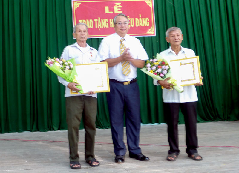 Trưởng Ban Tuyên giáo Tỉnh ủy Cao Văn Dũng trao huy hiệu Đảng cho hai đảng viên 55 tuổi đảng. Ảnh: Nguyễn Hoàng