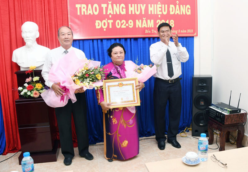 Trưởng ban Nội chính Tỉnh ủy Nguyễn Hải Châu trao Huy hiệu Đảng cho đảng viên. Ảnh: Hữu Hiệp