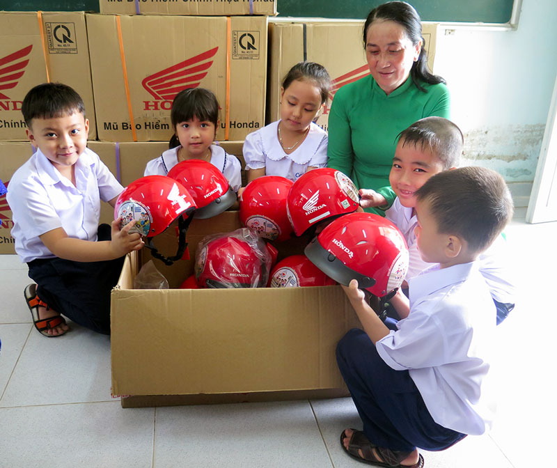 Honda Việt Nam trao tặng nón bảo hiểm nhằm kêu gọi trẻ đến trường phải đội mũ bảo hiểm đạt quy chuẩn kỹ thuật quốc gia. Ảnh: T. Thảo