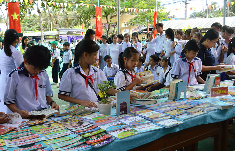 Các em học sinh tham gia đọc sách, báo trưng bày. Ảnh: Ánh Nguyệt