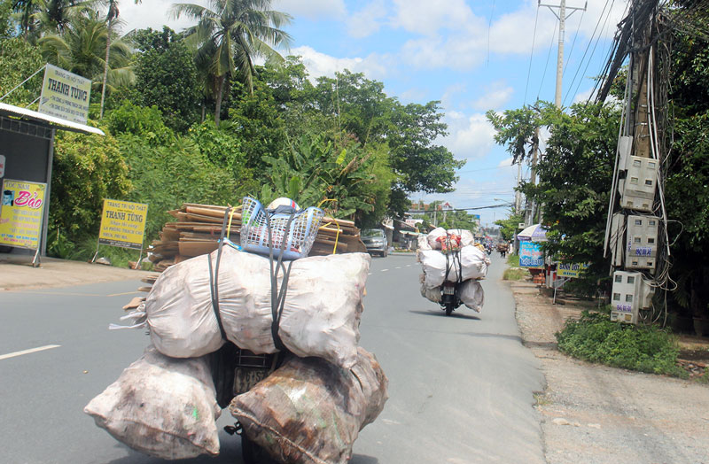 Xe máy chở phế liệu cồng kềnh dễ gây tai nạn giao thông Ảnh chụp khoảng 10 giờ 40 phút, ngày 5-9-2018 trên đường tỉnh 885, đoạn gần chợ Mỹ Lồng (Giồng Trôm).