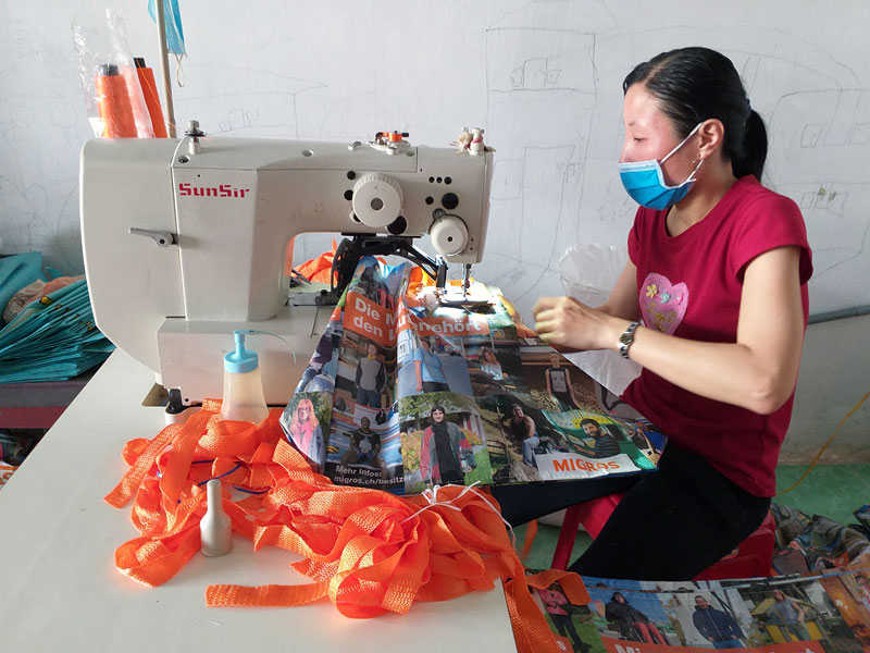 Lập nghiệp với nghề gia công may túi tự hoại Thợ may đang thực hiện khâu đóng quai túi trên máy điện tử.