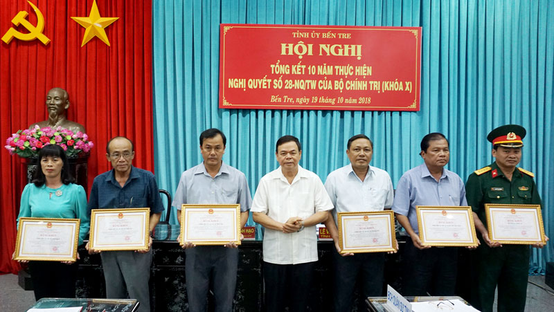 Xây dựng “Thế trận lòng dân” vững chắc trong khu vực phòng thủ Bí thư Tỉnh ủy Võ Thành Hạo trao bằng khen của UBND tỉnh cho các tập thể. Ảnh: Q.Hùng