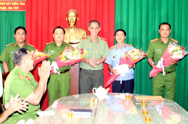 Thiếu tướng Nguyễn Văn Hoàng trao tặng hoa và tiền thưởng đột xuất cho cán bộ, chiến sĩ có thành tích phá án. Ảnh: H. Đức