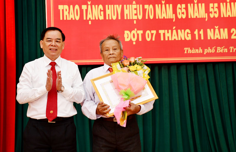 Phó bí thư Tỉnh ủy Trần Ngọc Tam trao Huy hiệu 70 năm tuổi đảng cho đồng chí Đỗ Minh Chính. Ảnh: Thu Huyền