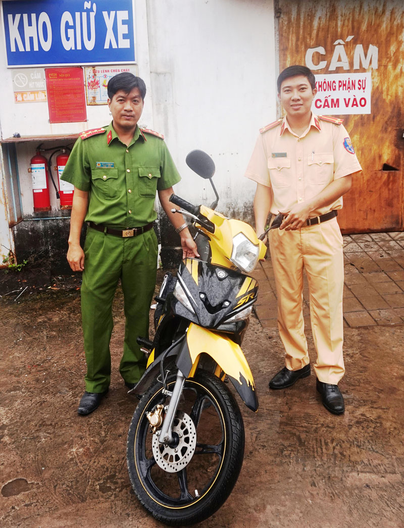Cán bộ Phòng Cảnh sát giao thông bàn giao xe mô tô bị mất trộm cho Cơ quan cảnh sát điều tra.