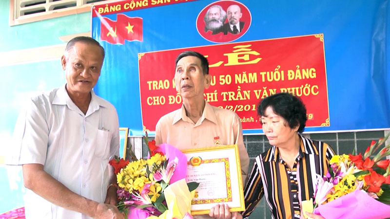 Đồng chí Trần Thanh Vũ trao huy hiệu 50 năm tuổi đảng cho đồng chí Trần Văn Phước. Ảnh: Việt Cường