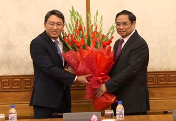 Đồng chí Phạm Minh Chính trao Quyết định và tặng hoa chúc mừng đồng chí Nguyễn Hải Ninh.