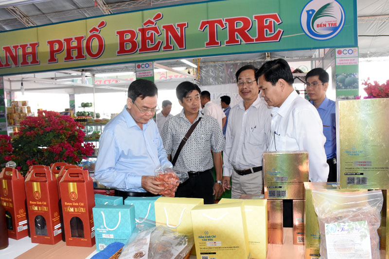 Bí thư Tỉnh ủy Võ Thành Hạo (bìa trái) tham quan sản phẩm nấm linh chi Bến Tre tại Hội chợ OCOP Bến Tre tại TP. Hồ Chí Minh.