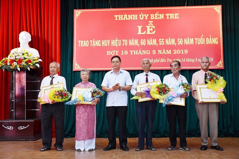 Bí thư Tỉnh ủy Võ Thành Hạo trao tặng huy hiệu Đảng cho các đảng viên của TP. Bến Tre. Ảnh: Hữu Hiệp