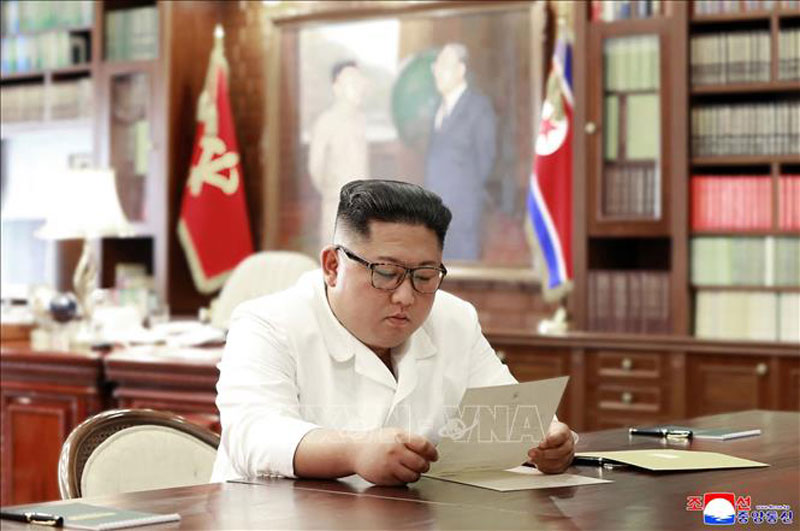 Chủ tịch Triều Tiên Kim Jong-un đọc bức thư gửi từ Tổng thống Mỹ Donald Trump, tại Bình Nhưỡng. Ảnh: AFP/TTXVN