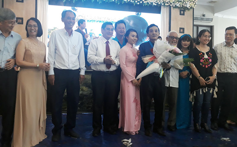 Các đại biểu tặng hoa chúc mừng họa sĩ Đoàn Việt Tiến.