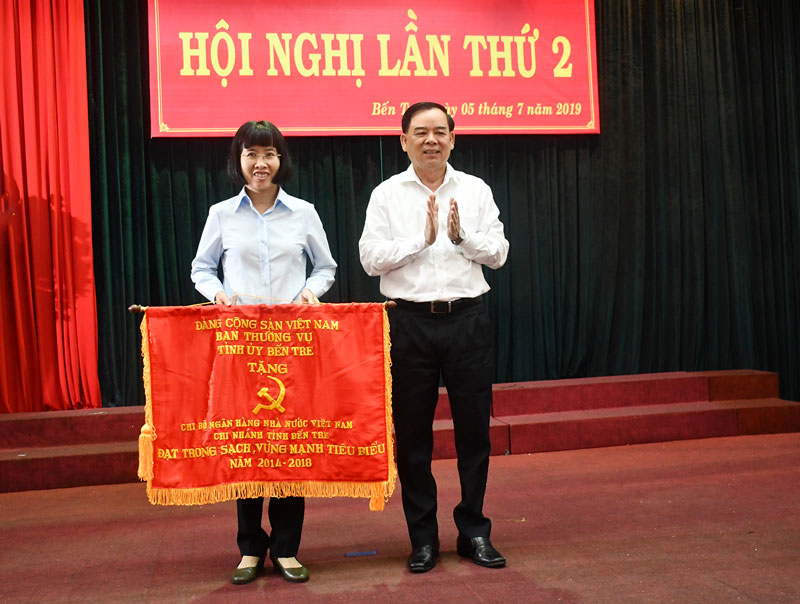 Phó bí thư Tỉnh ủy Trần Ngọc Tam trao Cờ thi đua cho Đảng bộ Ngân hàng Nhà nước Chi nhánh Bến Tre.