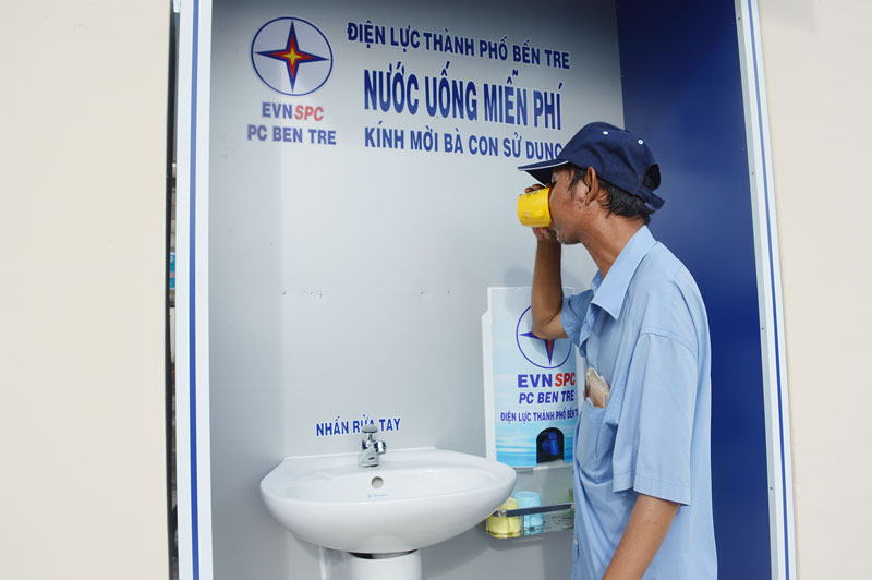 Một người dân đến uống nước tại khu vực bồn nước uống miễn phí của Điện lực TP. Bến Tre.