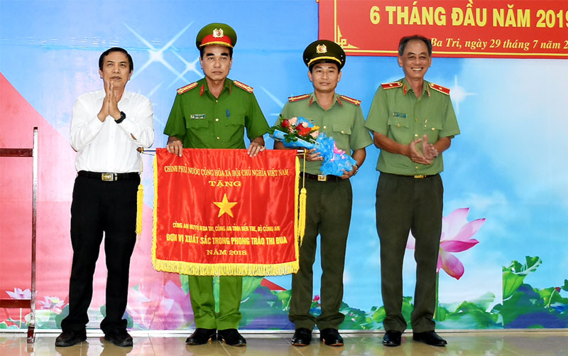 Công an huyện Ba Tri sơ kết công tác 6 tháng đầu năm 2019 và nhận Cờ thi đua của Chính phủ Chủ tịch UBND tỉnh Cao Văn Trọng (bìa trái), Thiếu tướng Nguyễn Văn Hoàng (bìa phải) trao Cờ thi đua của Chính phủ cho lãnh đạo Công an huyện Ba Tri. Ảnh: Q. Hùng