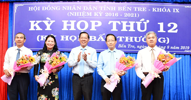 Bí thư Tỉnh ủy, Chủ tịch HĐND tỉnh Phan Văn Mãi trao hoa chúc mừng các đồng chí được bầu vào UBND, HĐND tỉnh.