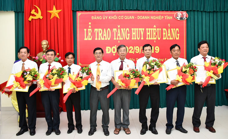 Phó bí thư Thường trực Đảng ủy Khối Cơ quan - Doanh nghiệp Nguyễn Văn Huỳnh trao Huy hiệu Đảng cho đảng viên.