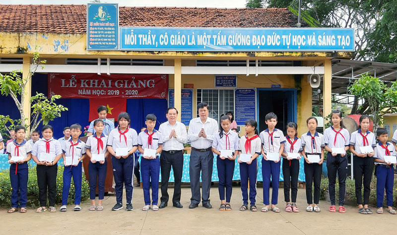 Phó bí thư Thường trực Tỉnh ủy Trần Ngọc Tam và Chủ tịch UBND huyện Ba Tri Dương Minh Tùng trao học bổng cho học sinh. Ảnh: Khánh Duy