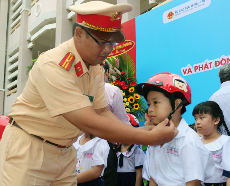 Tặng nón bảo hiểm cho học sinh lớp một. Ảnh: Phan Hân