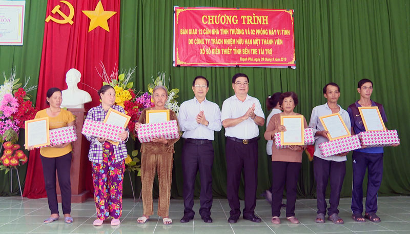 Bí thư Huyện ủy Nguyễn Trúc Sơn và đơn vị tài trợ trao quyết định bàn giao nhà và tặng quà cho các hộ gia đình.