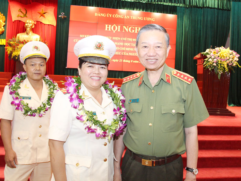 Trung tá Nguyễn Thị Thu Thủy chụp ảnh lưu niệm cùng Đại tướng Tô Lâm - Bộ trưởng Bộ Công an tại Hội nghị sơ kết 3 năm thực hiện Chỉ thị số 05-CT/TW do Đảng ủy Công an Trung ương tổ chức.  Ảnh: NVCC