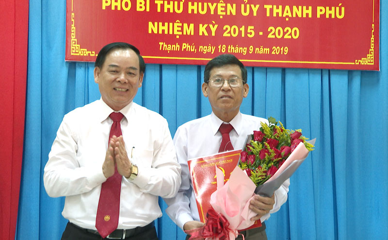 Phó bí thư Thường trực Tỉnh ủy Trần Ngọc Tam trao quyết định và tặng hoa chúc mừng đồng chí Phạm Văn Bé Năm. Ảnh: Minh Mừng