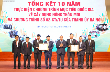 Thủ tướng trao “Bằng chứng nhận đạt chuẩn nông thôn mới” cho huyện Gia Lâm, huyện Quốc Oai. Ảnh: VGP/Quang Hiếu