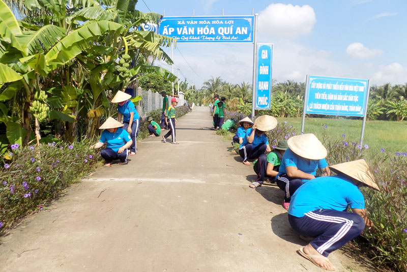 Đội thiếu niên bảo vệ môi trường cùng phụ nữ ấp dọn dẹp vệ sinh môi trường tại tuyến đường ấp Quí An.