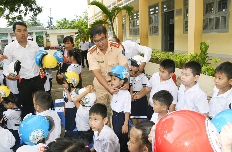 Tuyên truyền về việc đội mũ bảo hiểm cho học sinh tại Trường Tiểu học Mỹ Thạnh An (TP. Bến Tre).