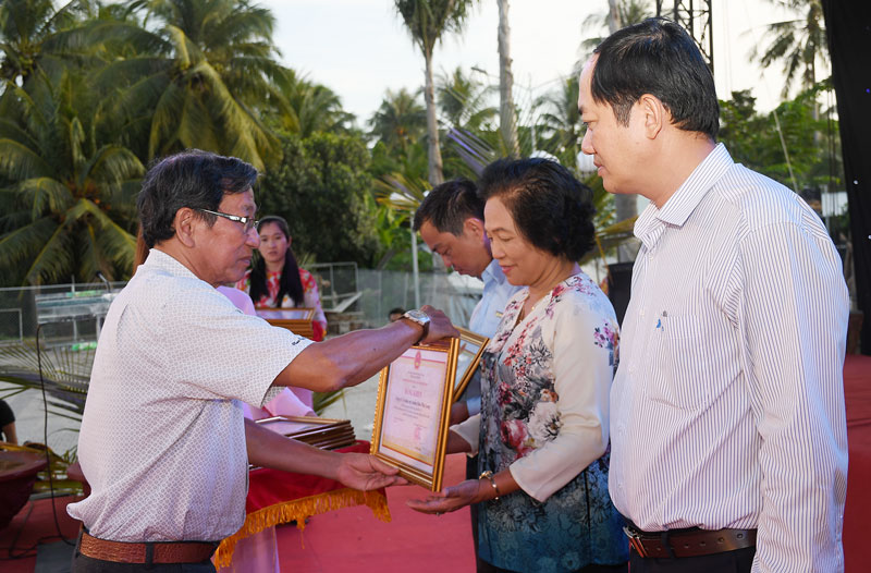 Trao bằng khen của UBND tỉnh cho doanh nghiệp tiêu biểu ngành dừa. Ảnh: H.H