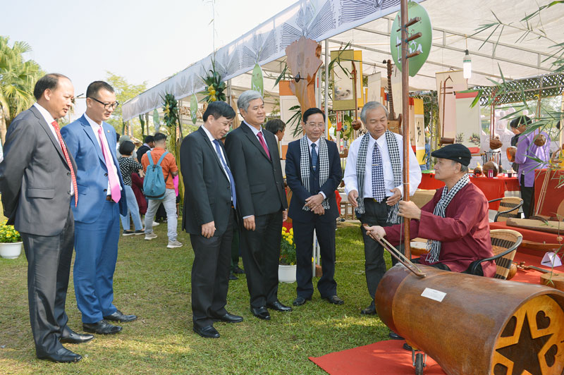 Các đại biểu và du khách tham quan gian hàng trưng bày nhạc cụ từ dừa và nghe nghệ nhân Bến Tre đờn trên nhạc cụ dừa. 