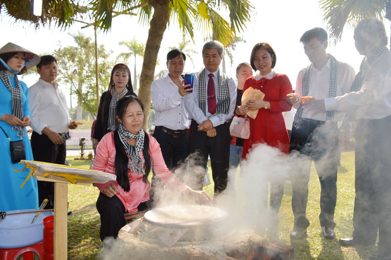 Đại biểu lãnh đạo tỉnh và du khách xem thực hành tráng bánh tráng do nghệ nhân Làng nghề bánh tráng Mỹ Lồng (Giồng Trôm) làm tại chỗ.