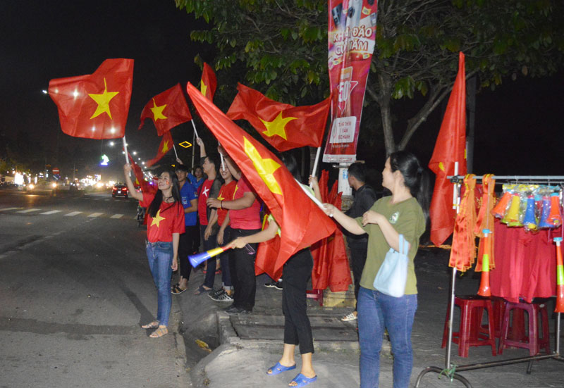 Các bạn trẻ phất cờ Tổ quốc mừng chiến thắng của đội tuyển bóng đá Việt Nam