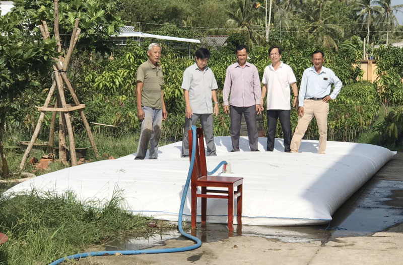 Chính quyền địa phương và ngành chức năng thử nghiệm độ bền của túi trữ nước ngọt tại UBND xã Phú Sơn. Ảnh: CTV