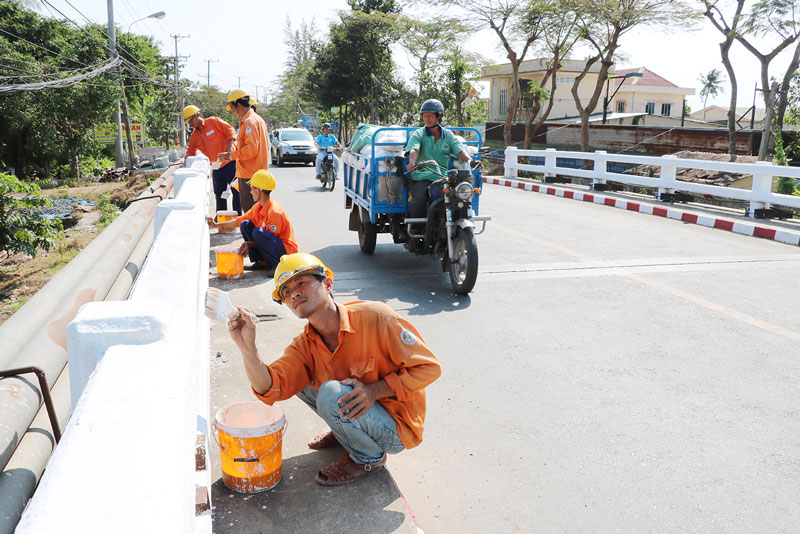 Công nhân Công ty CP công trình đô thị Bến Tre sơn lan can cầu Gò Đàng.